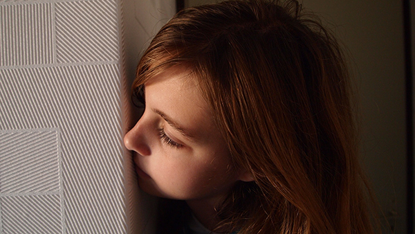 A girl peeking out behind a wall