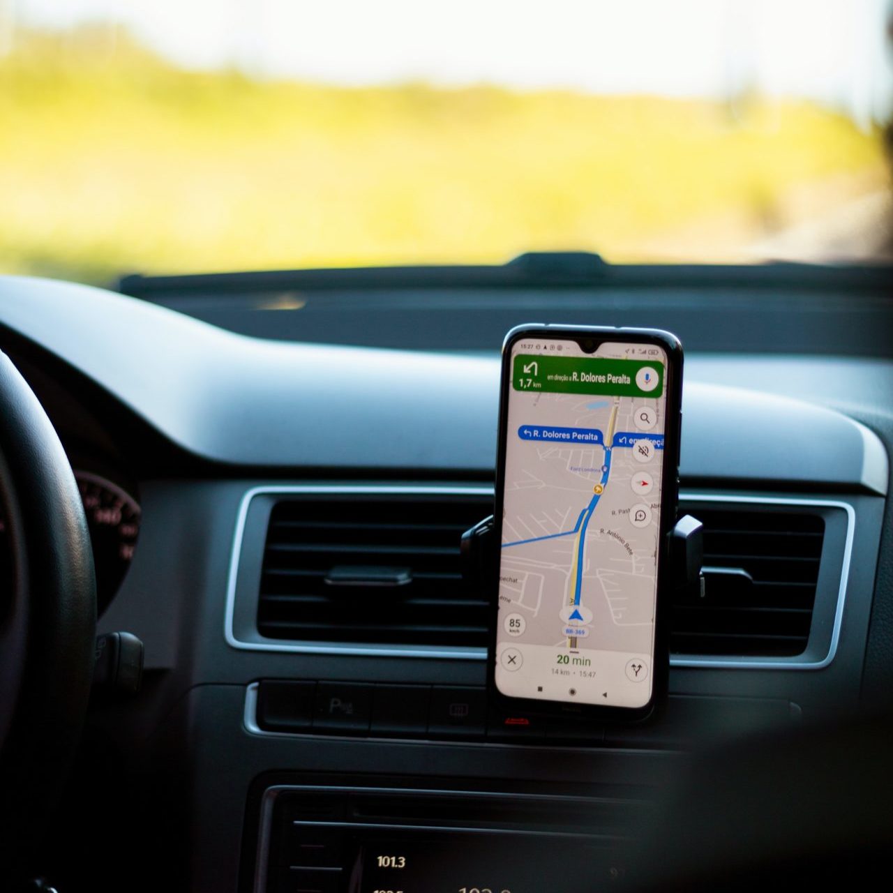 a person driving a car using a map on phone to navigate.