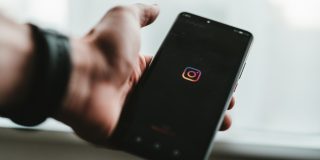 Man holding a phone running Instagram