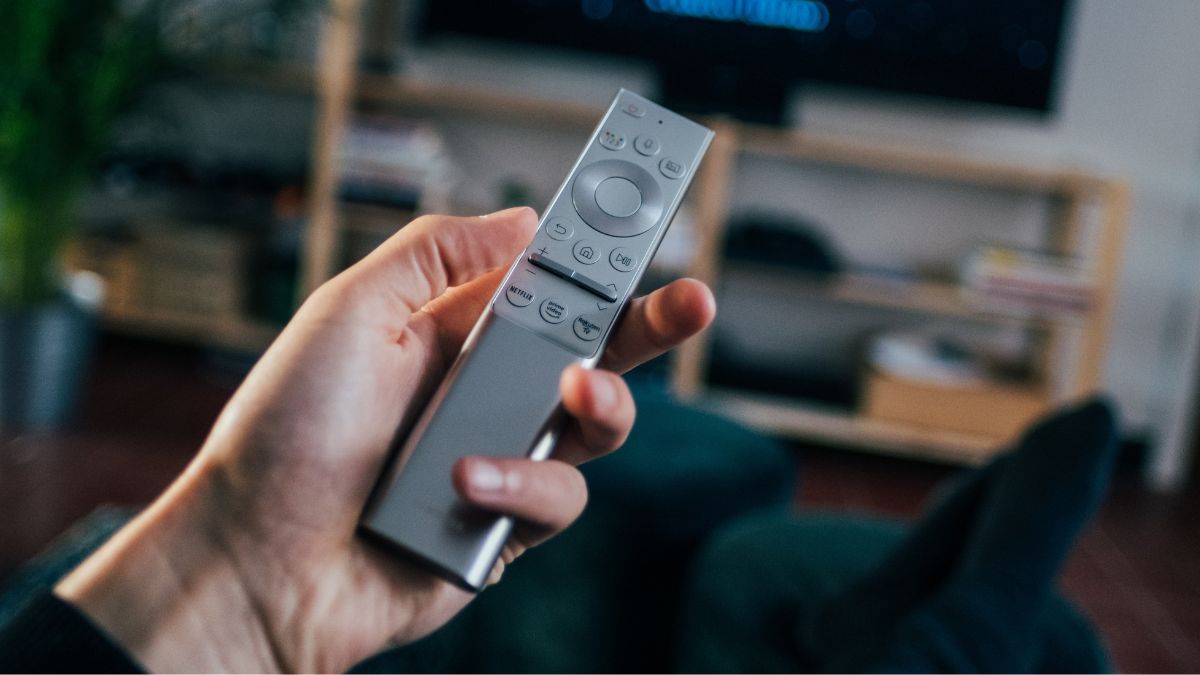 A man holding a TV remote
