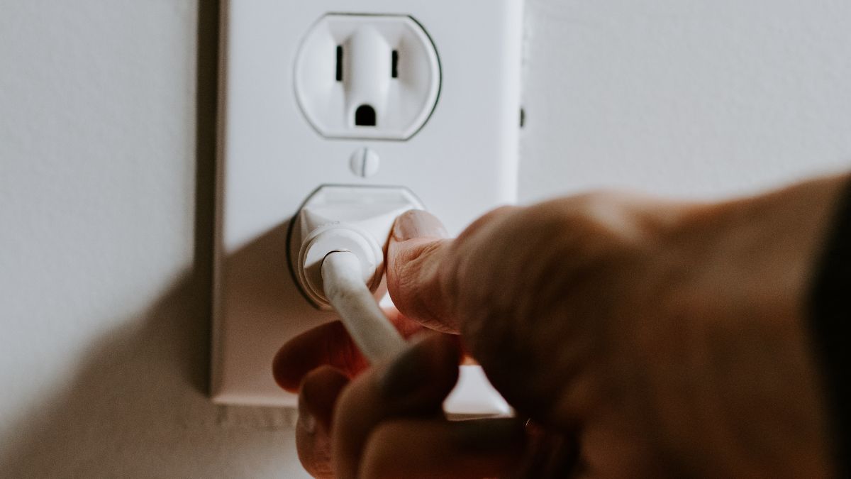 A person removing plug of a TV